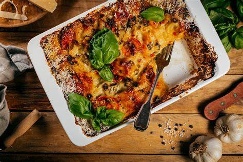 Obrázok ukazujúci vrstvenie lasagní s bešamelom a zeleninovou plnkou