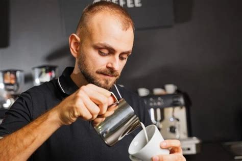 Barista nalieva espresso do speneného mlieka