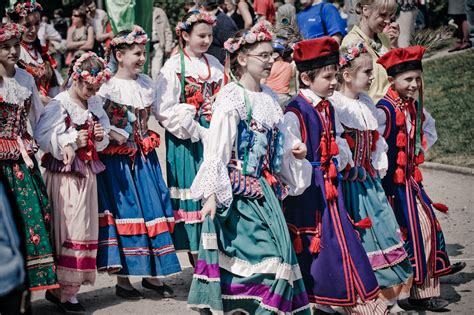 Skupina ľudí v tradičných slovenských krojoch, niektorí s kožuchmi obrátenými naruby