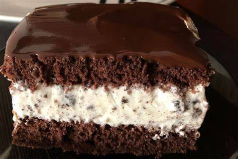Obrázok s obrázkom hotového nepečeného Oreo cheesecakeu, vrstveného s krémom a posypaného nasekanými oreo