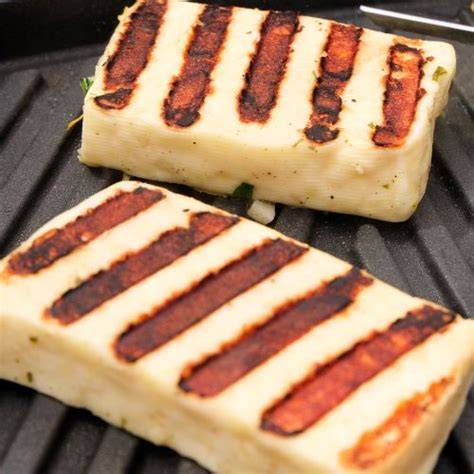 Rôzne prílohy a doplnky k plneným zemiakom: grilovaný syr Halloumi, pečené zemiaky, cícerový dresing, chrumkavá špargľa