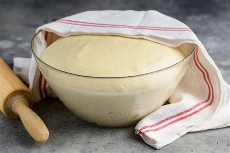 Obrázok ukazujúci kysnutie cesta v miske s kváskom a múkou